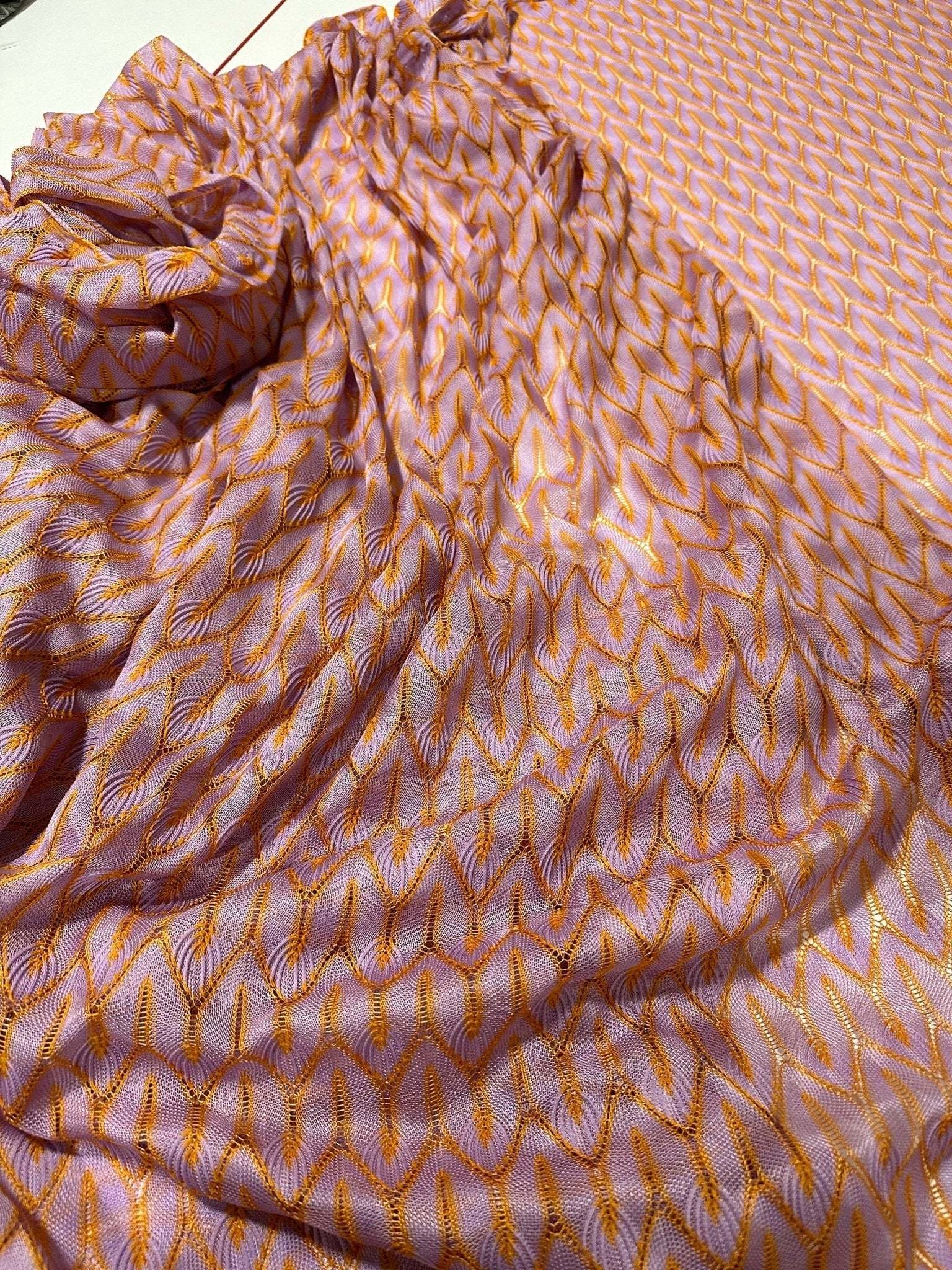Zigzag knit jersey mesh fabric in lilac and orange with lightweight breathable texture for fashion and crafting projects