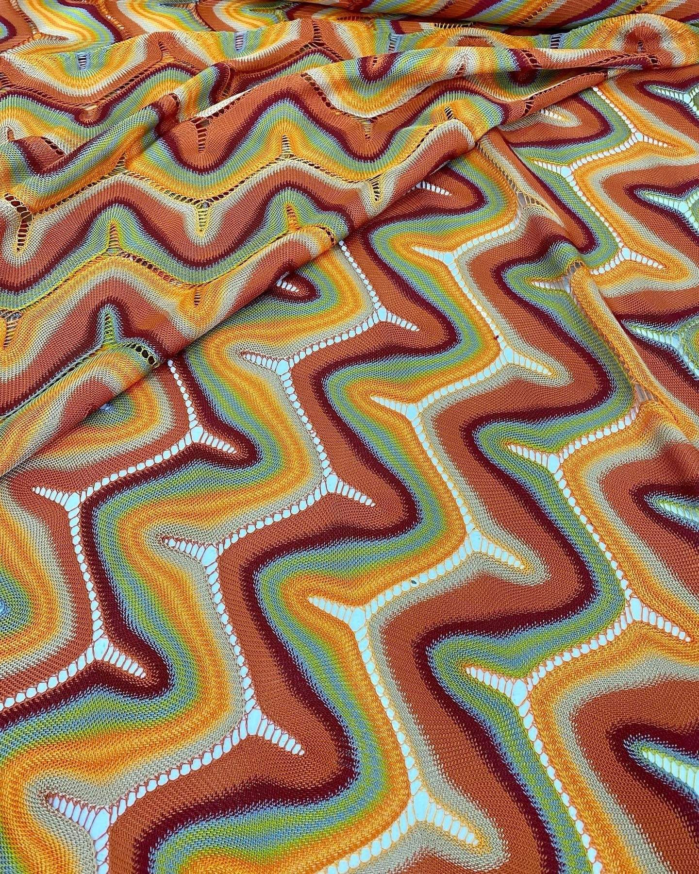Zigzag knit jersey mesh fabric with multicolor wavy pattern and soft texture ideal for fashion and craft projects