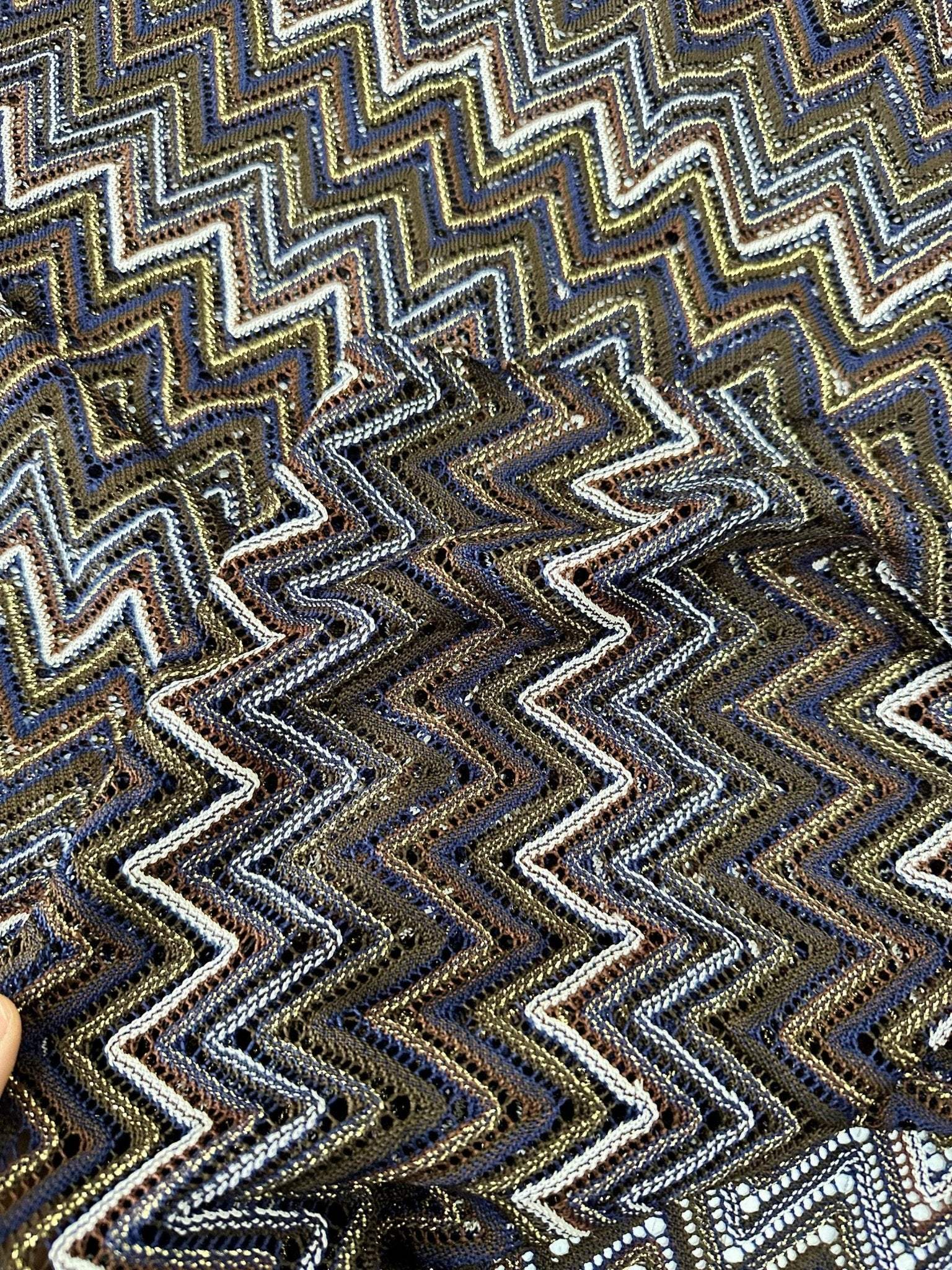 shimmering zigzag knitted mesh fabric with elastic jersey texture in blue, gold, and brown tones