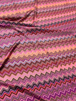 Colorful zigzag patterned mesh fabric with 4-way stretch in shades of pink, purple, and orange