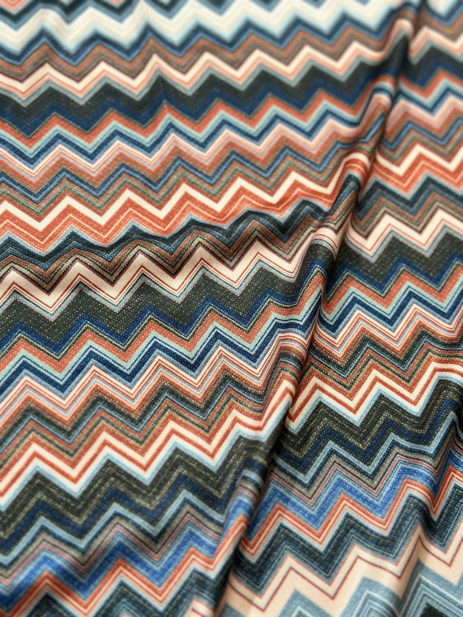 Close-up of colorful zigzag patterned fabric with 4-way stretch mesh texture and flexibility