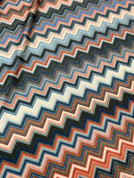 Close-up of colorful zigzag patterned fabric with 4-way stretch and breathable mesh texture for activewear and accessories