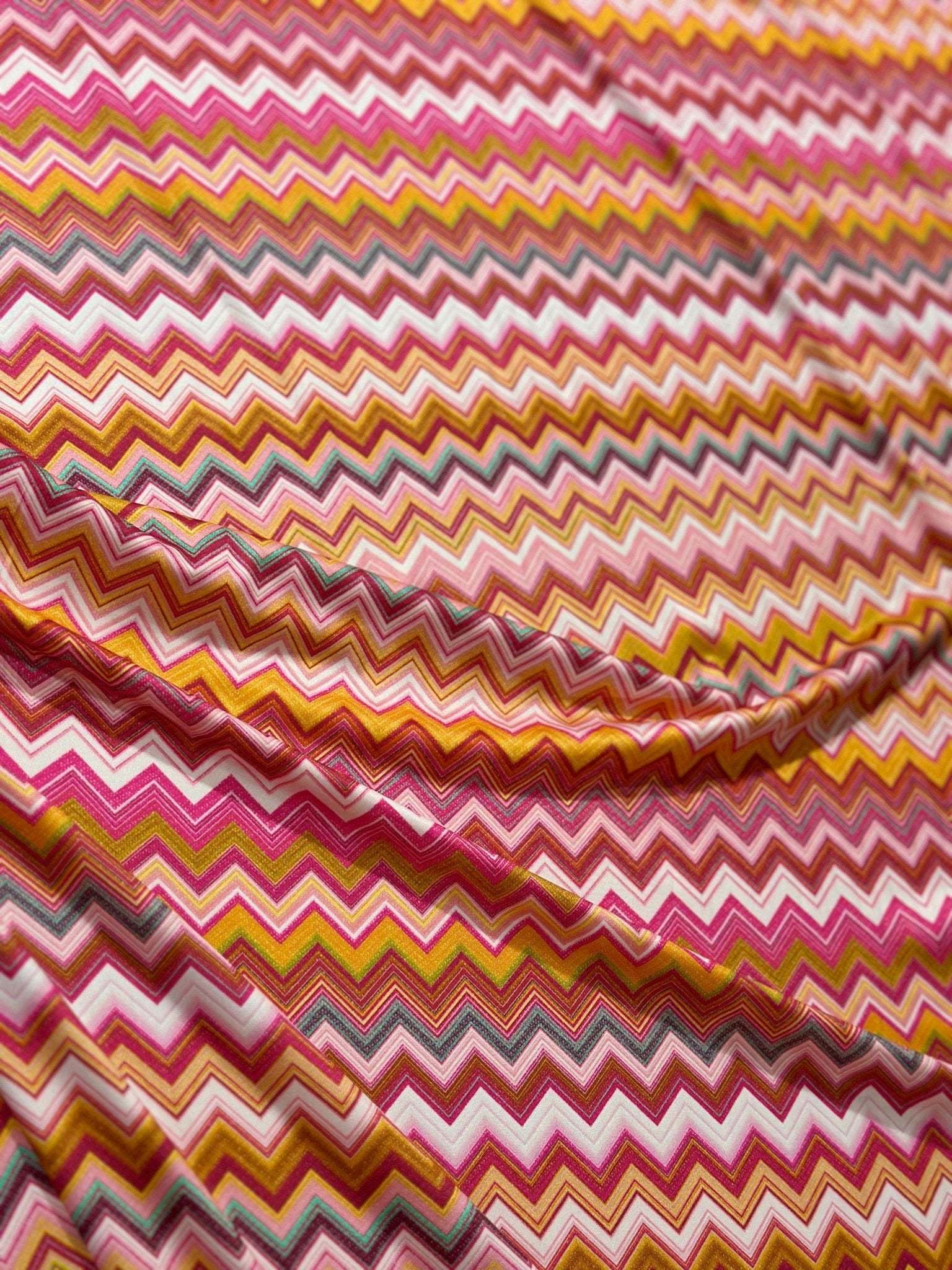 Close-up of colorful zigzag pattern fabric with 4-way stretch and 150cm width for versatile use