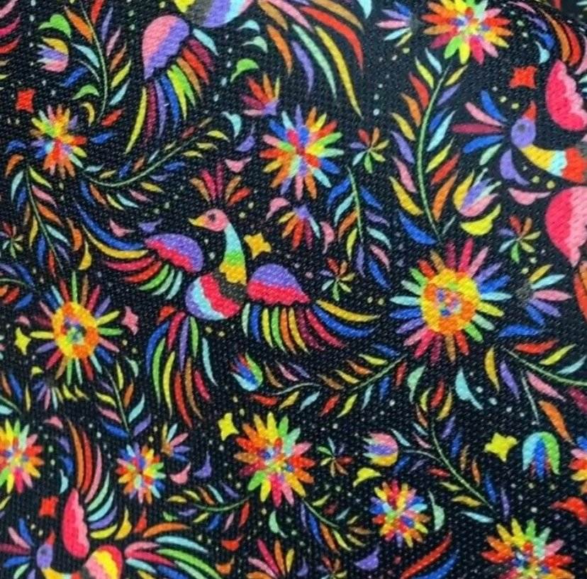 Colorful Otomi pattern upholstery fabric with vibrant floral and bird designs on black background