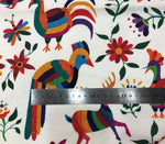 Otomi print outdoor pillow fabric with colorful birds, flowers, and animals on white background and ruler for scale