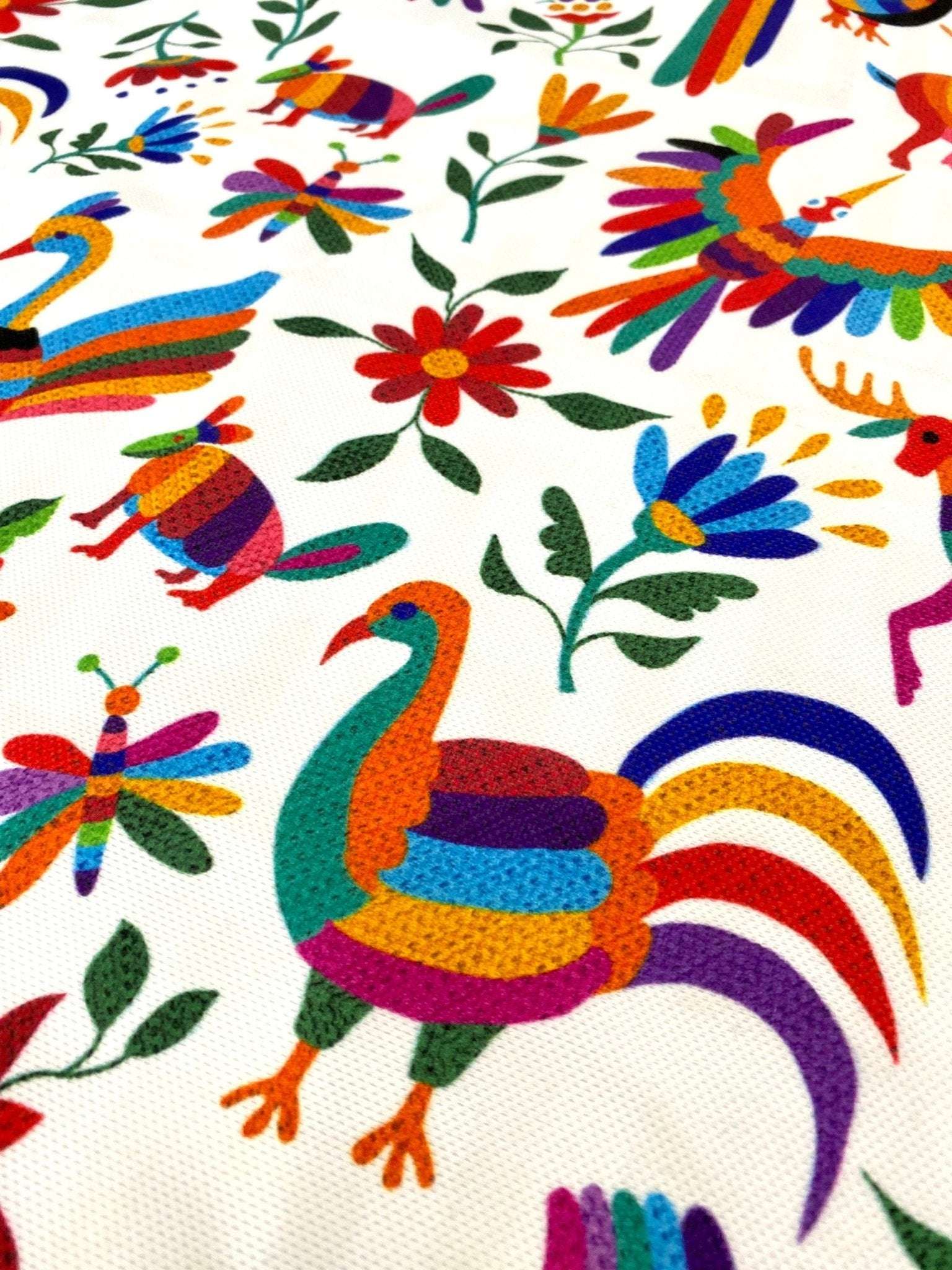 Colorful Otomi print outdoor pillow fabric with vibrant birds and floral designs on white background
