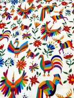 Colorful Otomi print fabric with vibrant birds, animals, and flowers for outdoor pillow upholstery.