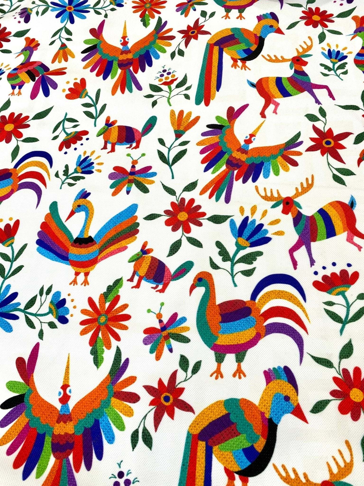 Colorful Otomi print fabric with vibrant birds, animals, and flowers for outdoor pillow upholstery.