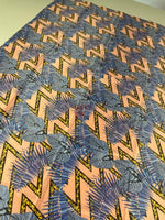 Modern geometric and tropical leaf print fabric with vibrant peach, blue, and black design