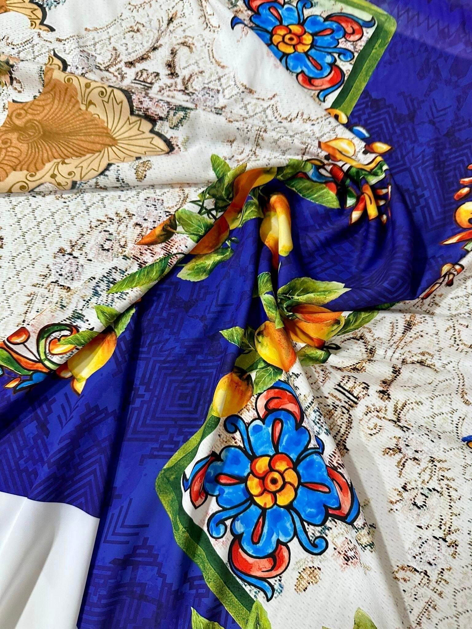 Close-up of vibrant Floral Mosaic Lemon Angel Pattern Fabric with blue, yellow, and orange floral and lemon designs on soft textured material