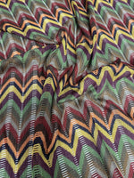 Multicolor chevron jacquard fabric with zigzag knit pattern in green, yellow, purple, and orange tones.