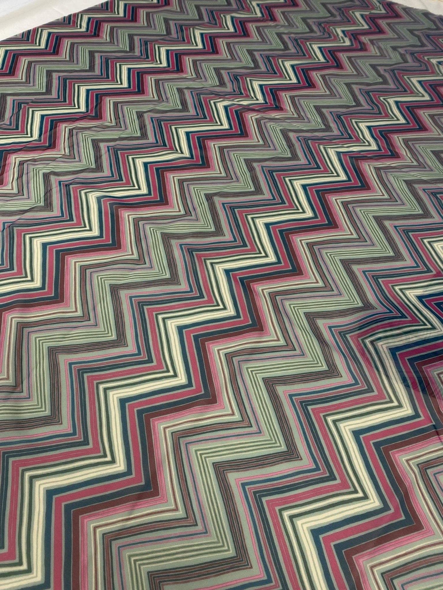 Multicolor chevron zigzag fabric with vibrant zigzag pattern in various colors, ideal for sewing and crafting.