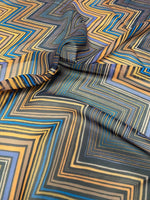 Multicolor chevron zigzag pattern fabric with blue, yellow, and black tones, ideal for sewing projects and home decor.