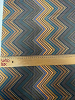 Multicolor chevron zigzag pattern fabric with blue, orange, and black tones, measuring 150cm wide