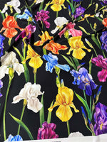 Colorful floral crepe fabric with vibrant irises on a black background, lightweight and breathable textile for sewing projects