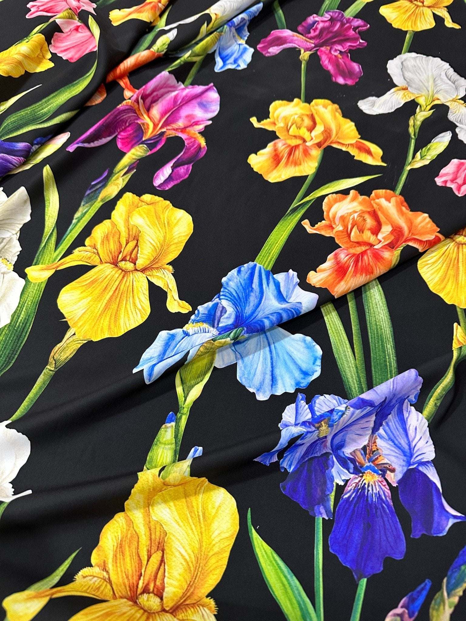Floral crepe fabric with vibrant multicolor flowers on a black background, lightweight and soft for sewing projects
