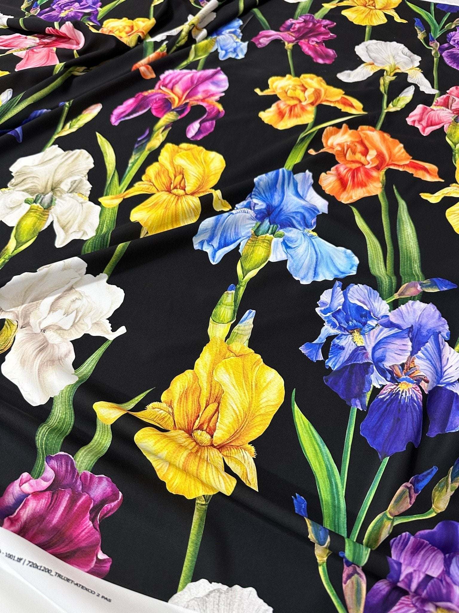 Floral crepe fabric with colorful iris flowers on black background, lightweight and breathable textile for dresses and blouses