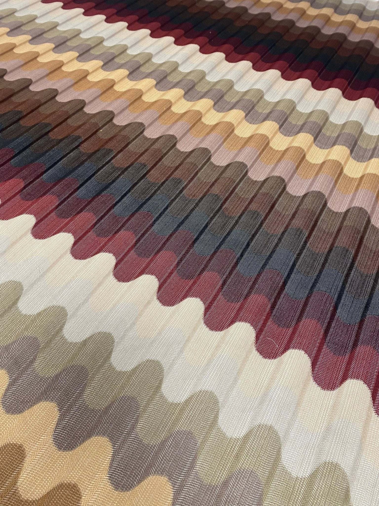 close-up of multicolor pleated wave fabric with zigzag knit pattern in earthy tones