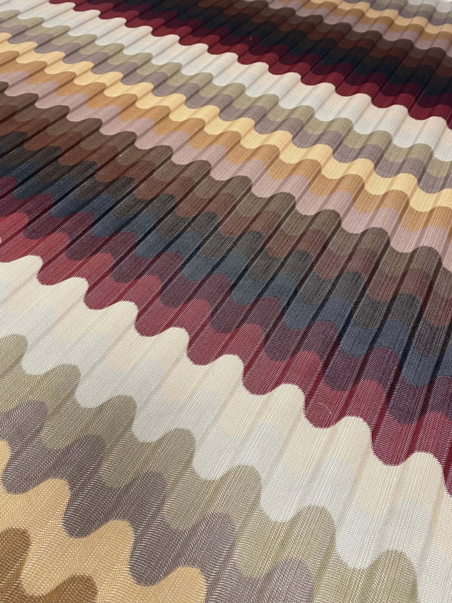 close-up of multicolor pleated wave fabric with zigzag knit pattern in earthy tones