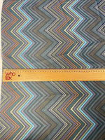 multicolor zigzag patterned fabric with ruler for scale showing vibrant chevron design in multiple colors