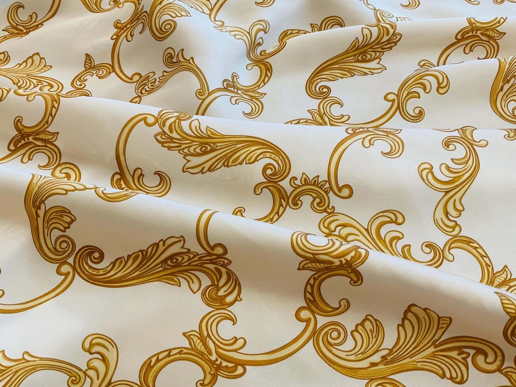 white fabric with gold baroque pattern close up texture