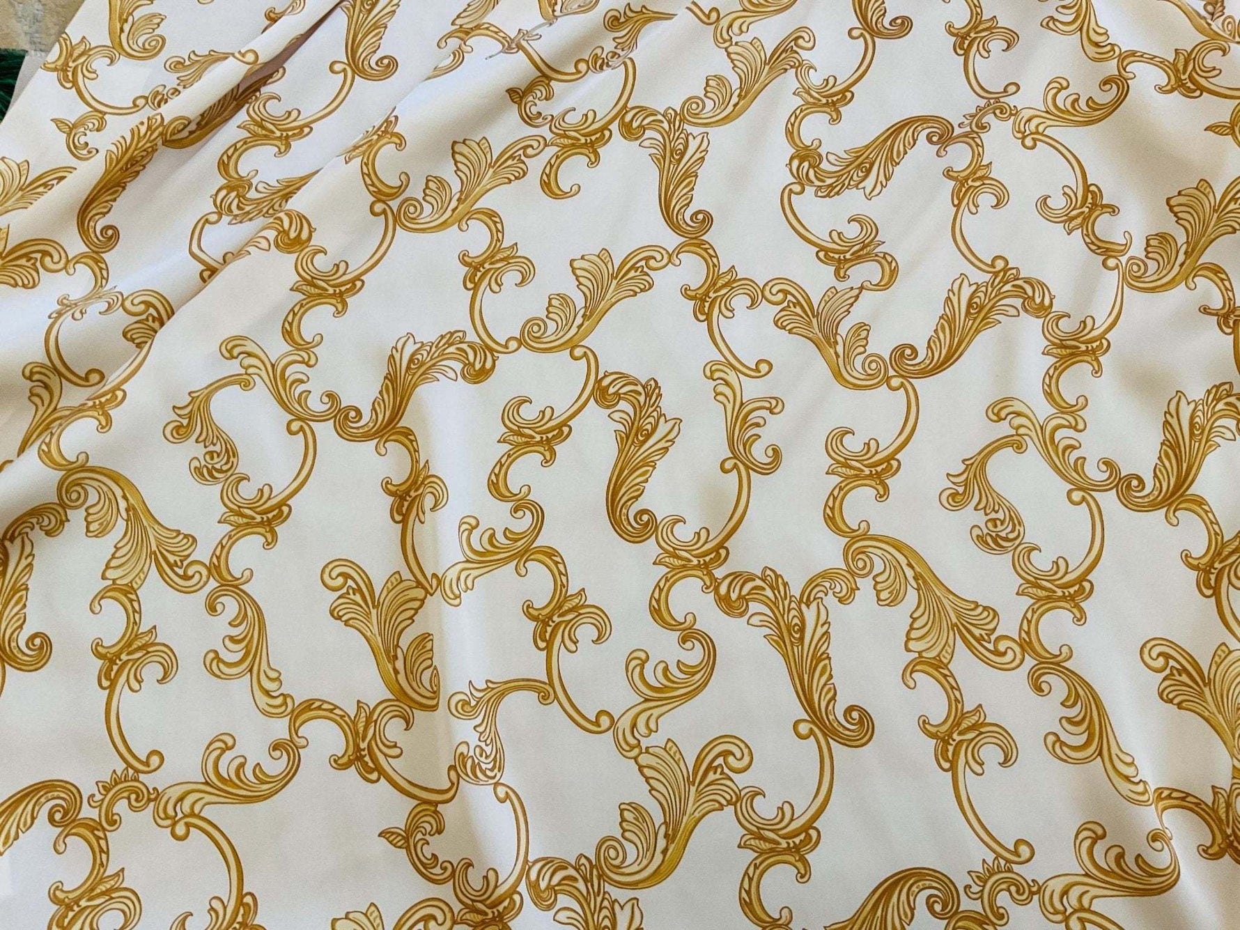 luxurious white fabric with intricate gold baroque pattern for dresswear