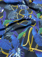 Navy blue fabric with leaf chain pattern featuring gold chains and tropical leaves