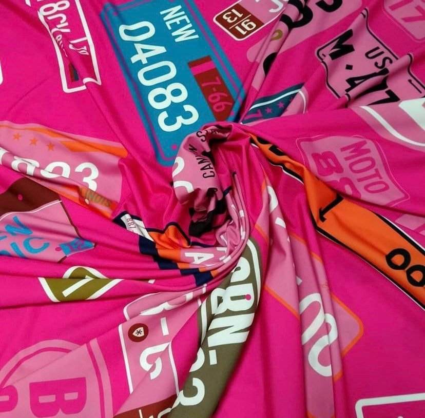 Bright pink fabric with colorful number plate patterns for crafts and sewing projects