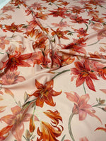 Orange and red lily floral fabric with vibrant flower pattern and soft texture