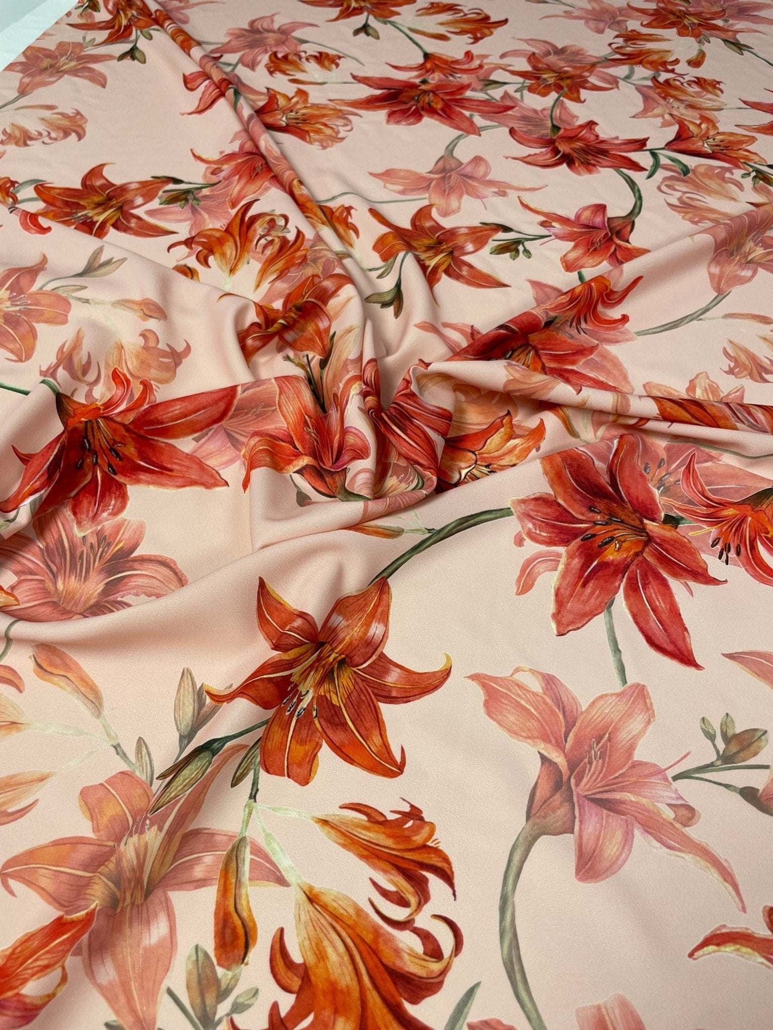 Orange and red lily floral fabric with vibrant flower pattern and soft texture