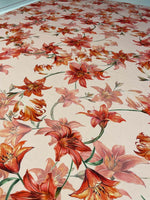 Orange and red lily floral fabric with vibrant flower pattern on soft material for sewing and crafting projects