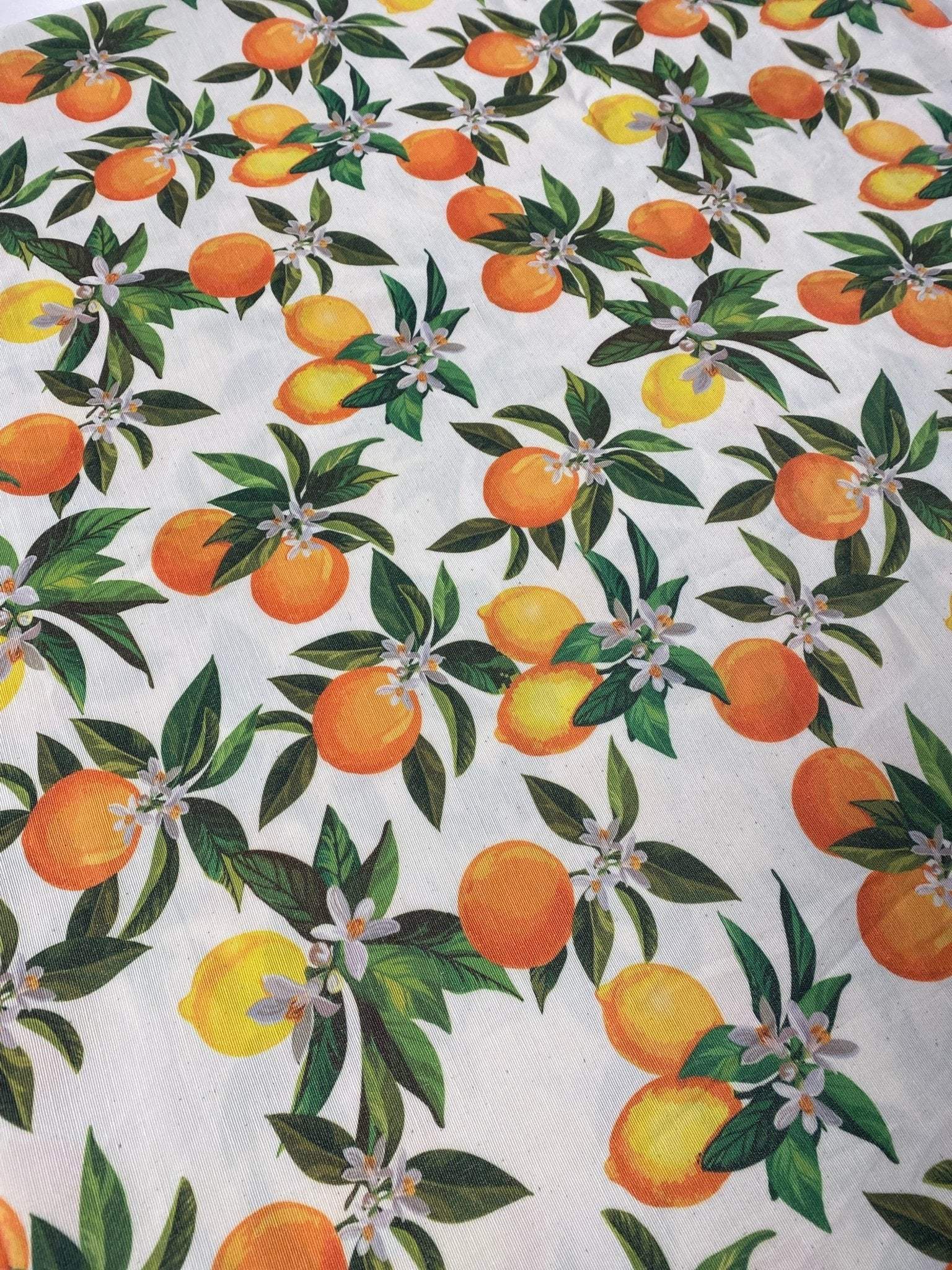 orange linen fabric with vibrant orange and yellow citrus fruit pattern and green leaves for crafting and home decor