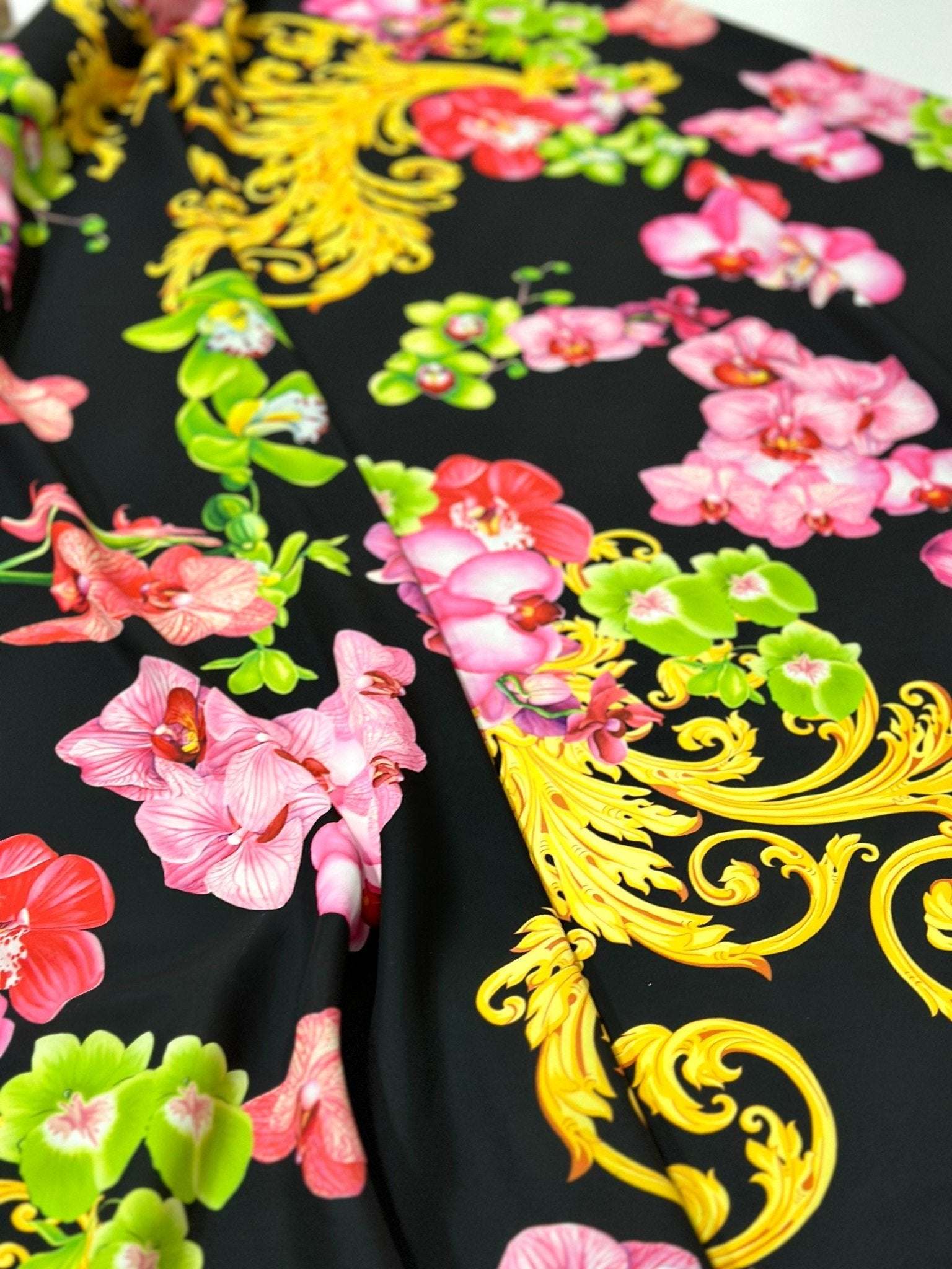 Orchid Baroque floral fabric with vibrant pink, red, and green flowers and intricate yellow baroque swirls on black background