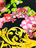 Close-up of Orchid Baroque Floral Fabric with vibrant pink orchids and ornate yellow baroque patterns on a black background