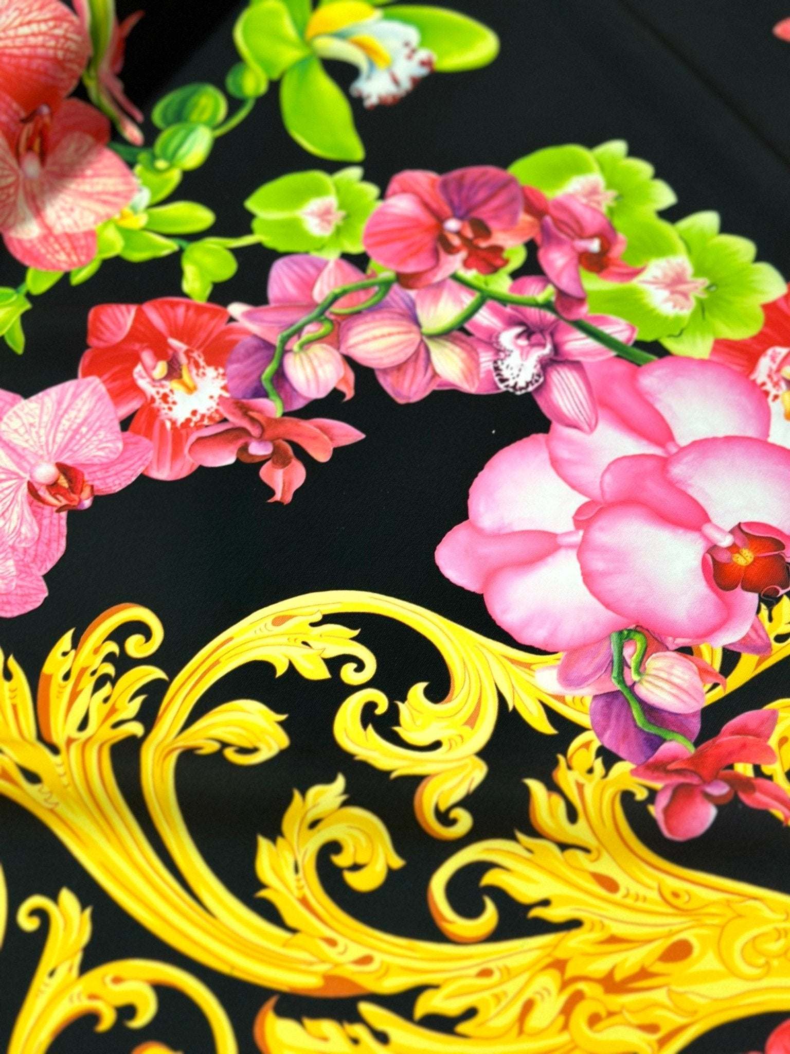 Close-up of Orchid Baroque Floral Fabric with vibrant pink orchids and ornate yellow baroque patterns on a black background