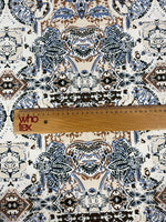 Ornamental ethnic print fabric in blue, brown, and beige with intricate patterns and ruler for scale