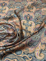 close-up of black and orange paisley fabric with intricate decorative pattern and fabric folds