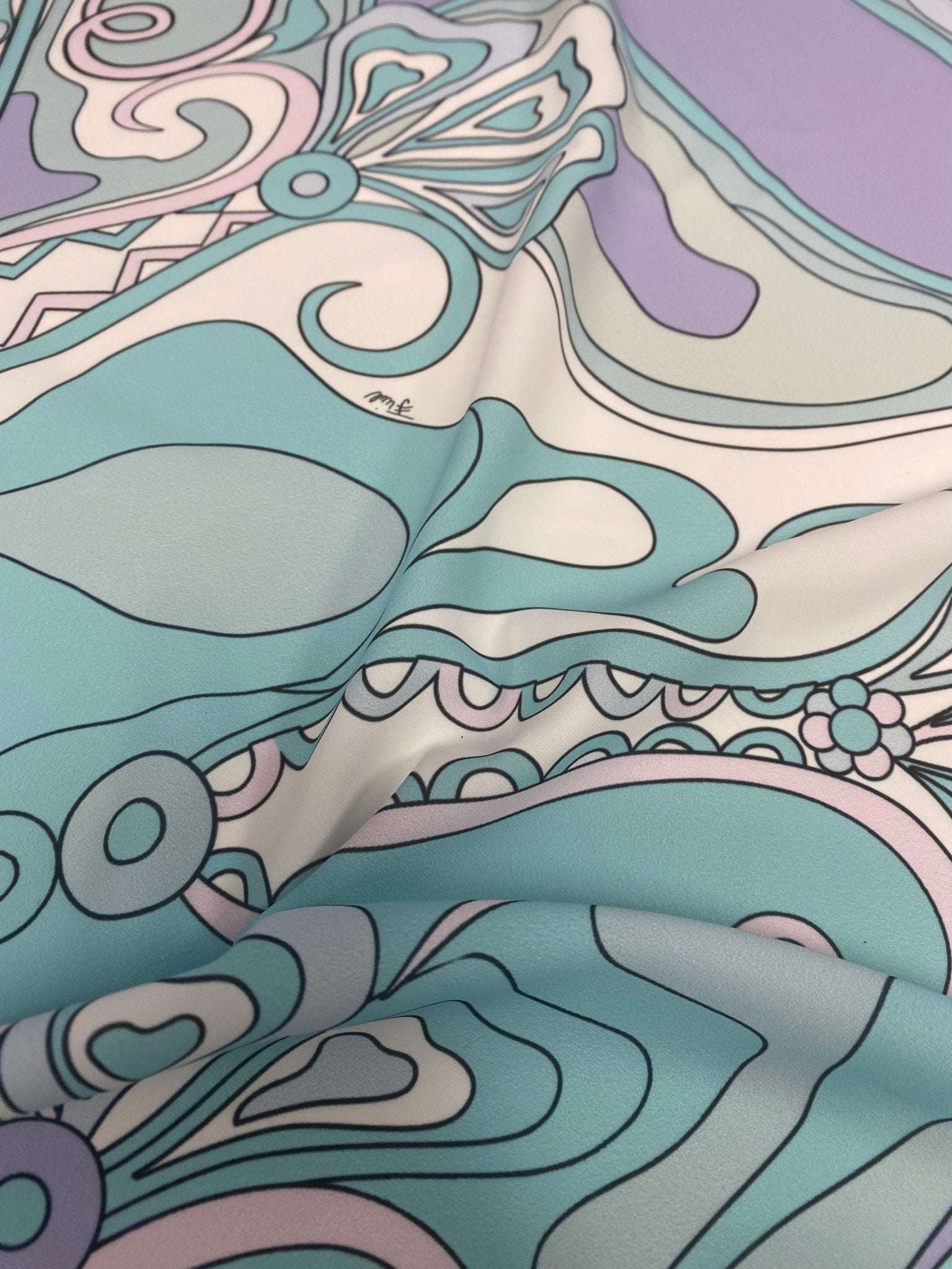 Pastel abstract swirl fabric with soft pastel colors and intricate swirling patterns close-up