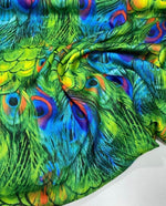 Vibrant green Peacock Feather Fabric with colorful feather pattern, ideal for sewing and upholstery projects, 150cm wide.