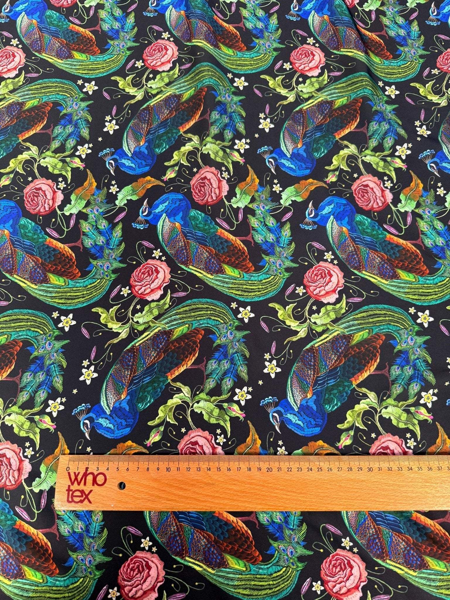Colorful Peacock Rose Fabric with vibrant peacock and rose patterns on black cotton material