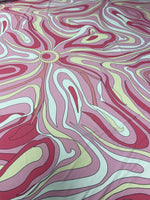 Pink and yellow psychedelic swirl print fabric with vibrant abstract design and smooth texture