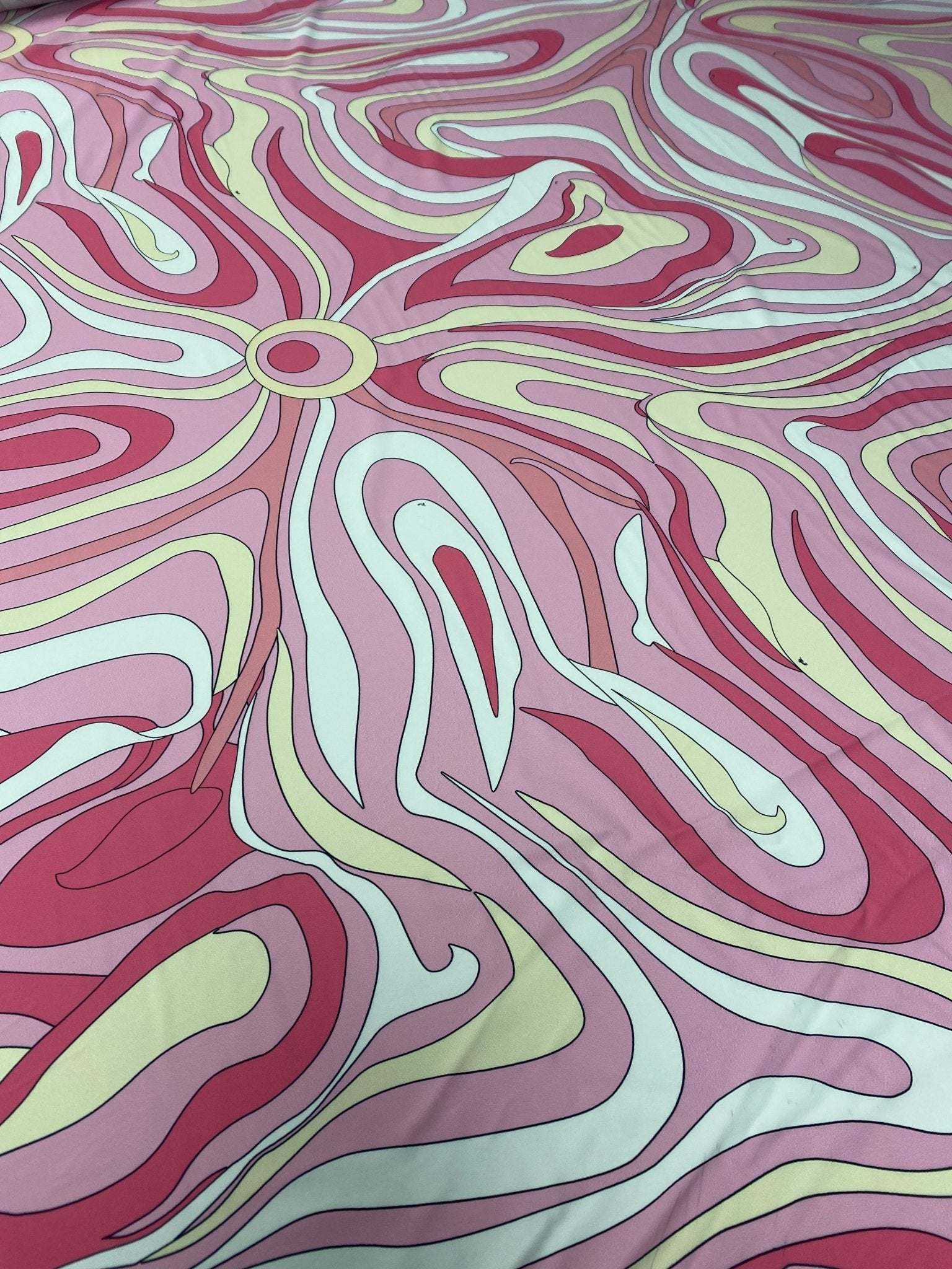 Pink and yellow psychedelic swirl print fabric with vibrant abstract design and smooth texture