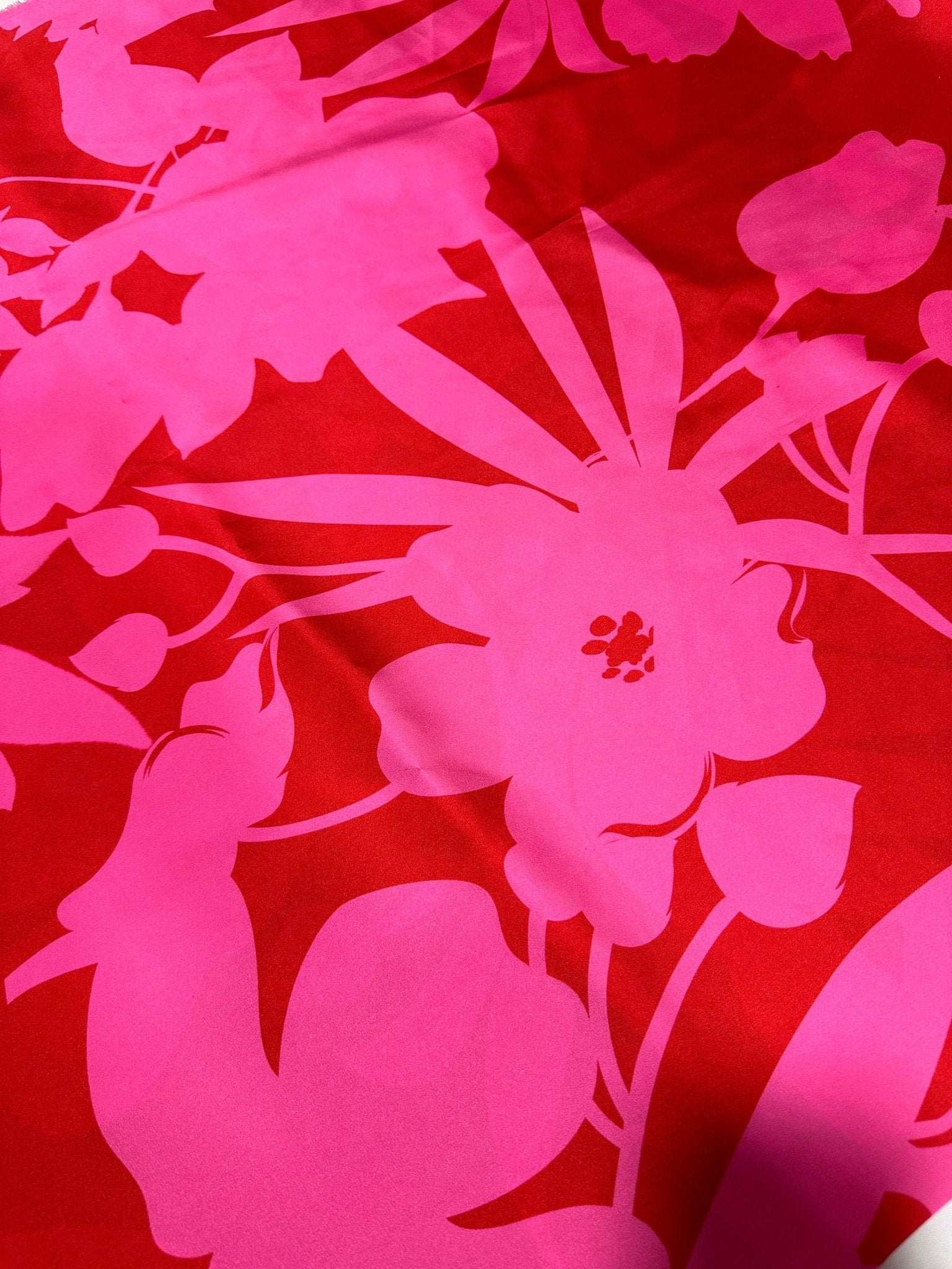 Vibrant tropical pink and red fabric with bold floral pattern for sewing projects