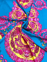 Silky fabric with pink baroque pattern on bright blue and yellow background, luxurious and elegant textile for dresses and decor