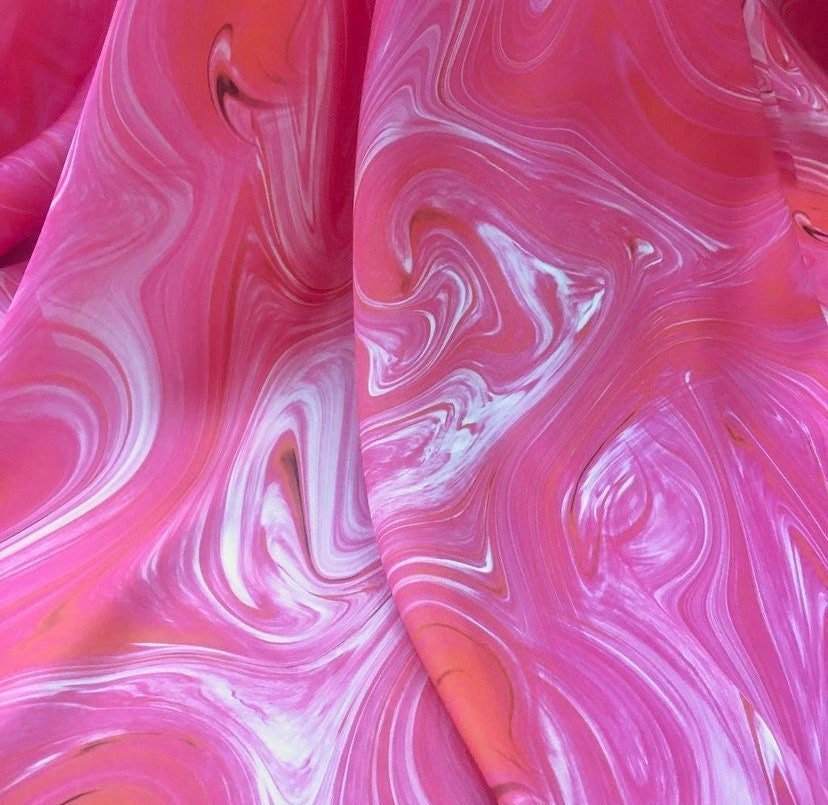 Pink tie dye fabric with vibrant swirling patterns in shades of pink and white, ideal for crafts and sewing projects