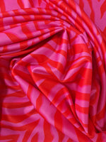 Red and pink tiger striped patterned fabric with vibrant bold design and 150cm width