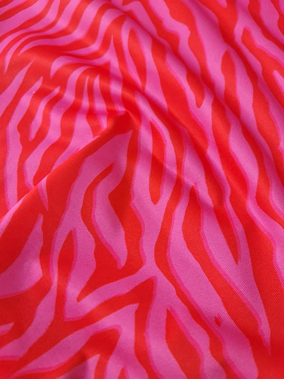 Red and pink tiger striped patterned fabric with vibrant bold design and 150cm width for clothing and crafts