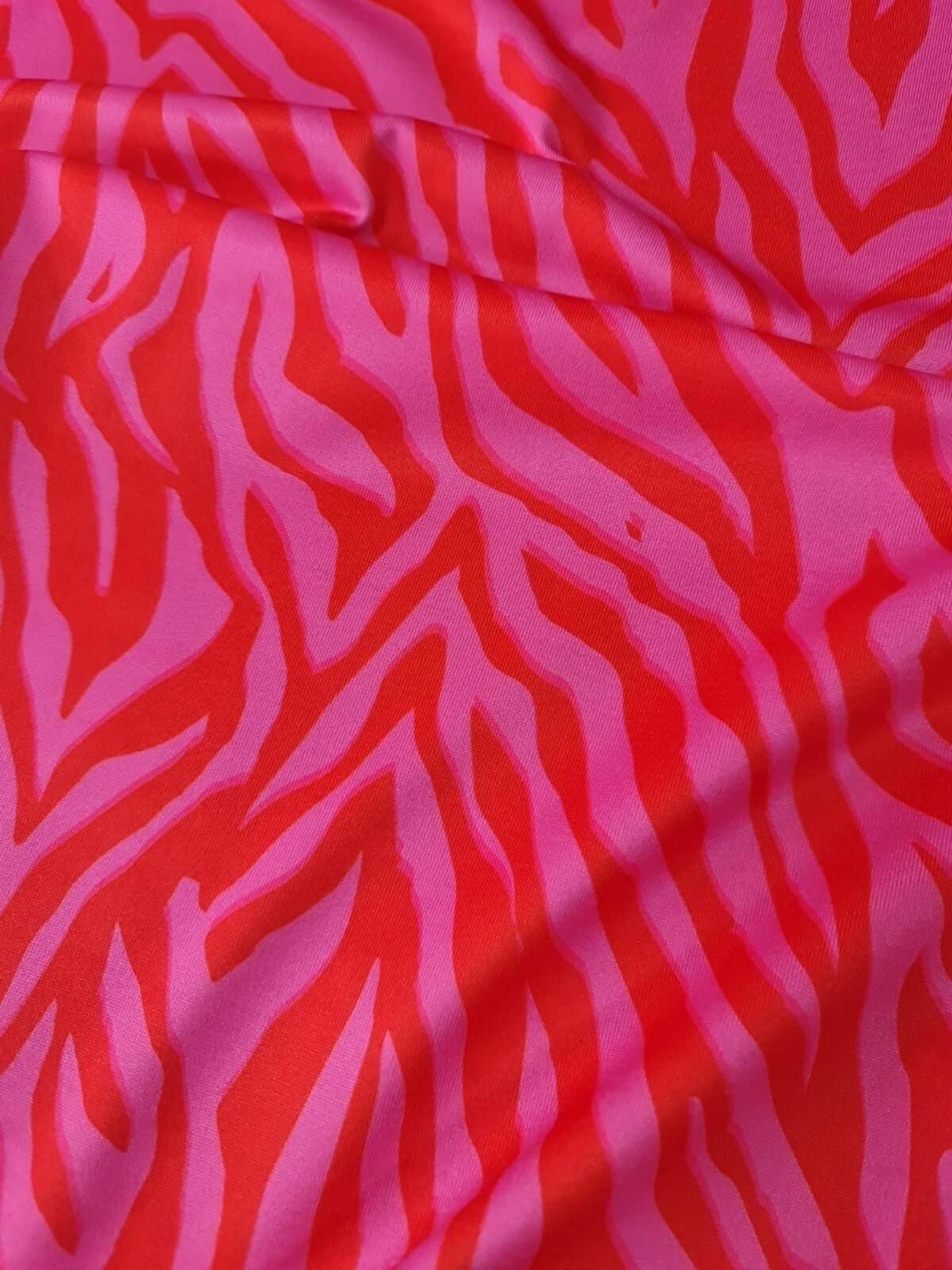 Red and pink patterned tiger striped fabric with vibrant bold design and 150cm width