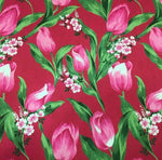 Pink tulip fabric with vibrant red background and green leaves floral pattern