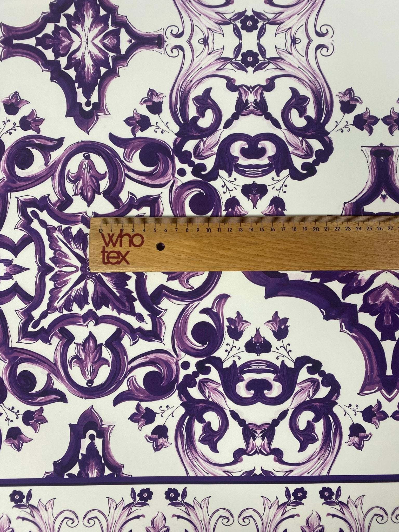 Purple Baroque floral pattern fabric with intricate decorative designs and ruler for scale